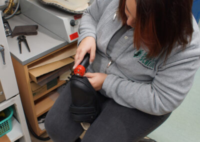 Laufsohlen von Konfektionsschuhen werden per Hand aufgeschnitten, um Platz für Einbauten zu schaffen.